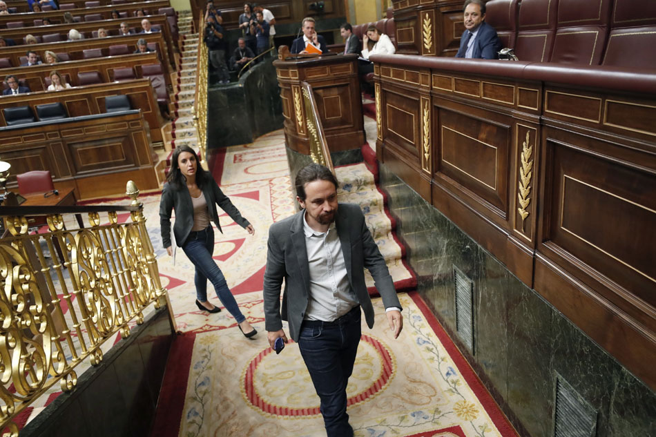 El líder de Podemos, Pablo Iglesias (c), junto a la portavoz parlamentaria de Podemos, Irene Montero (detrás), al inicio hoy del pleno del Congreso de los Diputados.