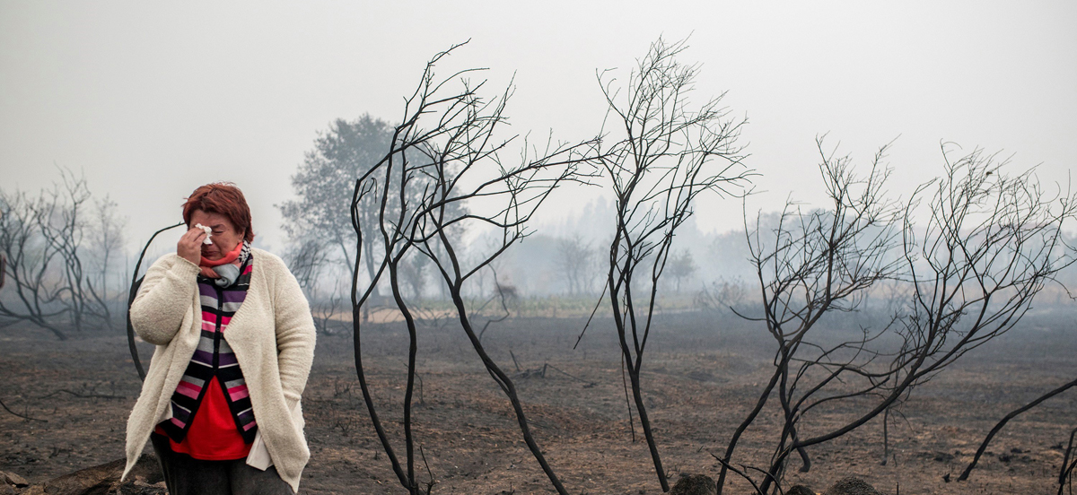 una mujer llora ante el paisaje calcinado por el fuego, en la zona de Abelenda das Penas (Carballeda de Avia).