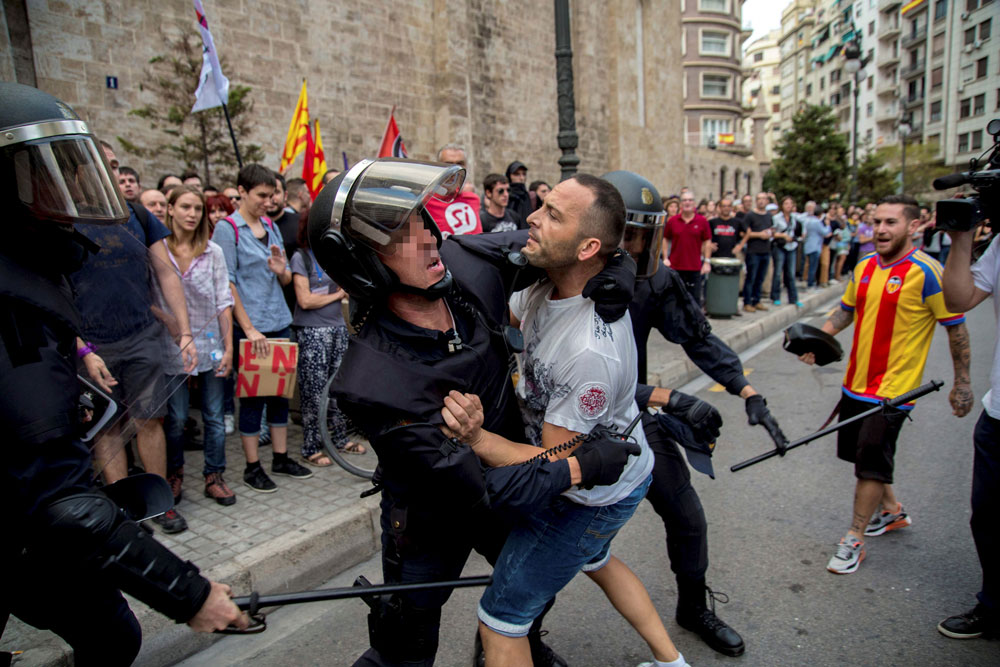 Agentes de la policía tratan de controlar a un joven durante la tradicional manifestación de entidades de izquierda y nacionalista del 9 d'Octubre llevada a cabo el pasado día 9 de octubre por el centro de Valencia. EFE