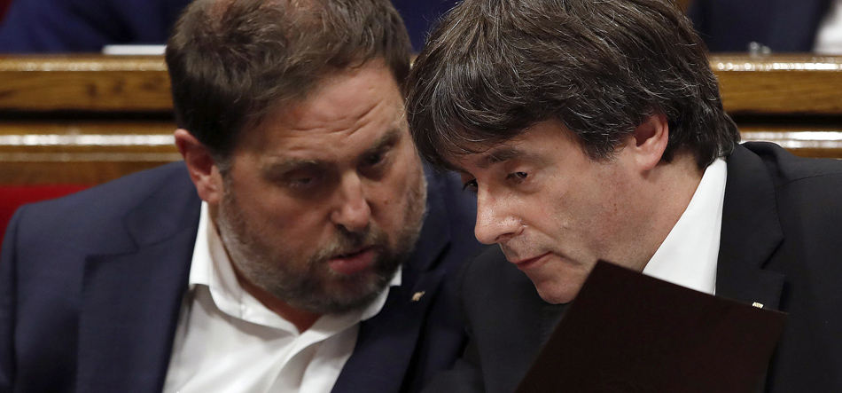  El presidente de la Generalitat, Carles Puigdemont (d), y el vicepresidente Oriol Junqueras (i), en sus escaños del Parlamento. EFE