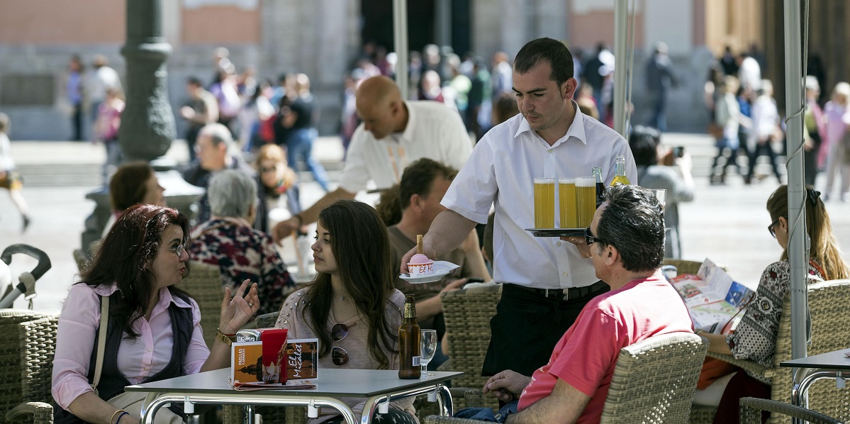Un camarero sirve bebidas en una terraza en Valencia