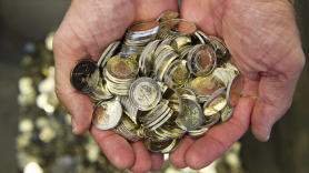 Un hombre sostiene varias monedas de euro.