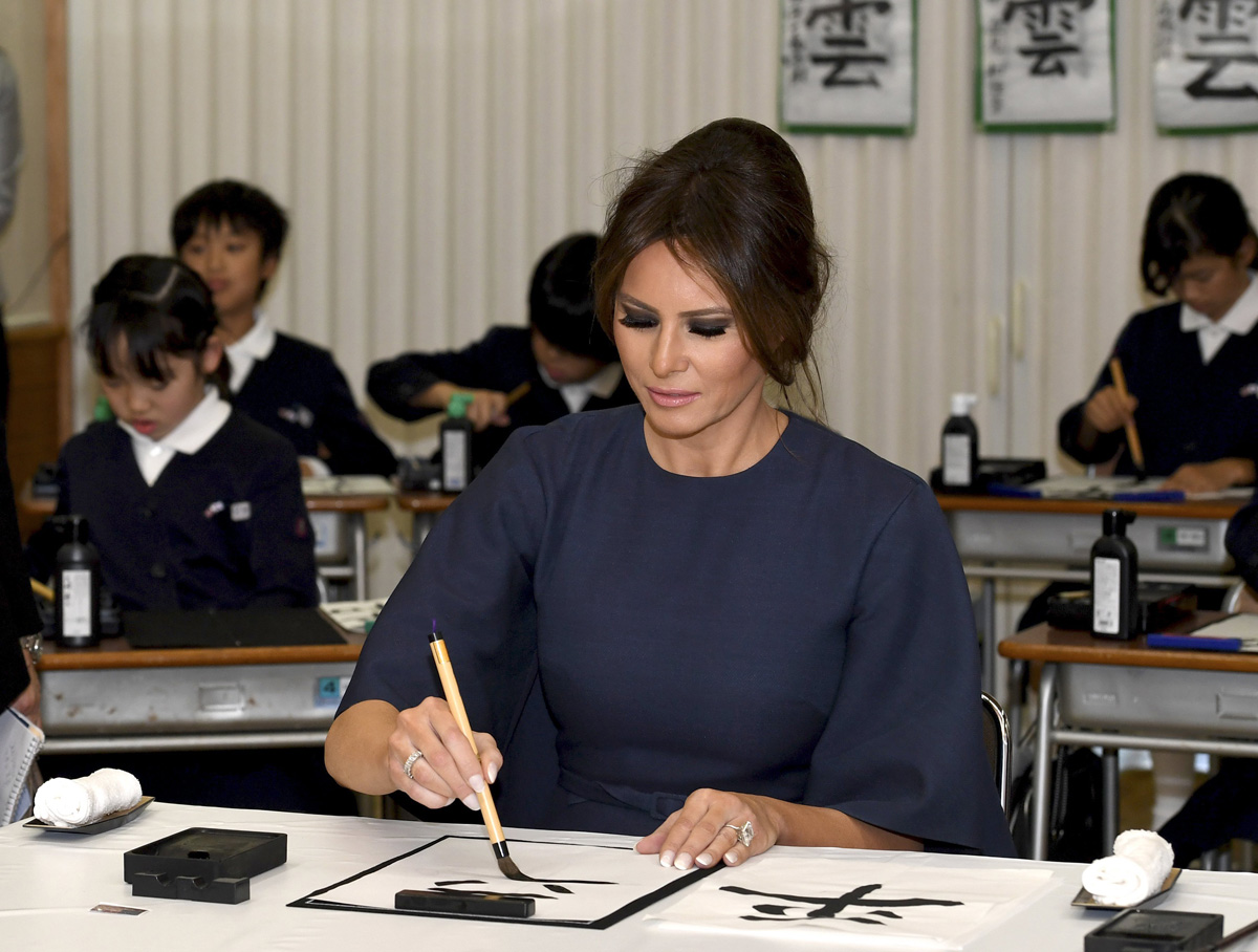 Melania Trump practica caligrafía japonesa en una escuela de Tokio