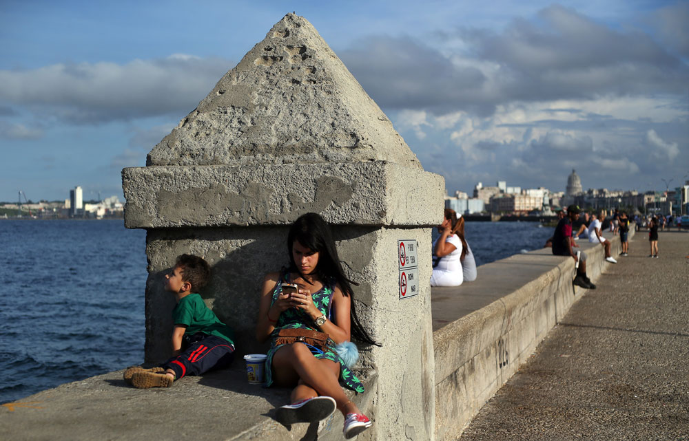 Una joven se conecta a internet en el muro del Malecón en La Habana (Cuba)