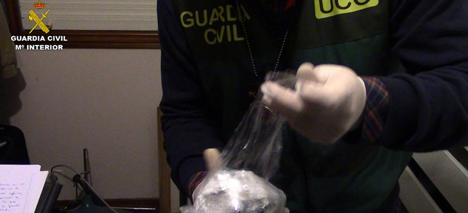 Un agente de la Guardia Civil requisa una bolsa con droga