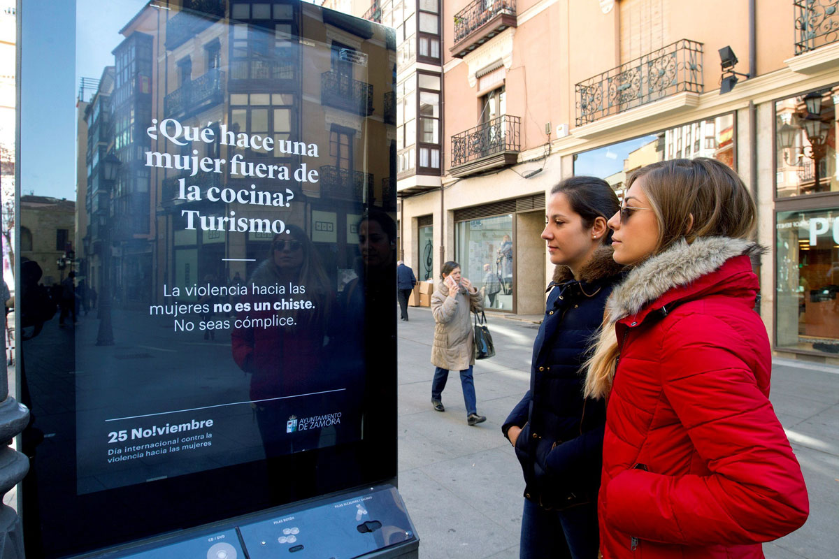 Dos mujeres observan uno de los carteles ubicados por las calles zamoranas de la campaña iniciada por el Ayuntamiento de Zamora que busca concienciar sobre la violencia machista.