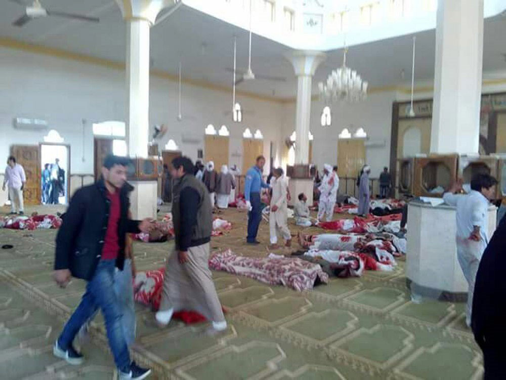 Varias personas permanecen junto a cuerpos sin vida en el interior una mezquita contra la que se ha perpetrado un ataque en Egipto.