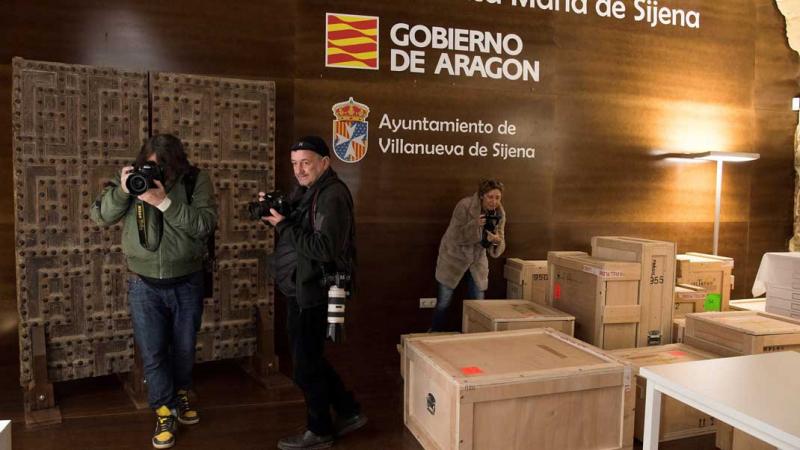 Fotógrafos sacan imágenes de las cajas con los bienes trasladados desde Lérida hasta el Monasterio de Villanueva de Sijena
