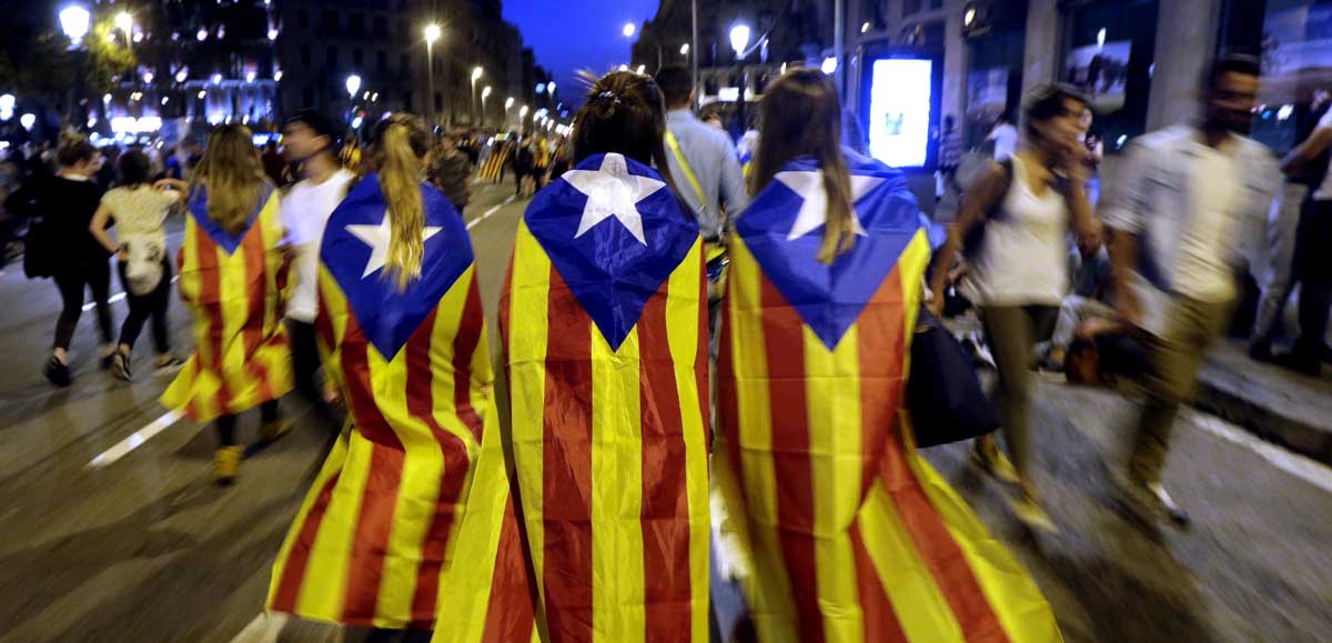 Varias jóvenes con banderas esteladas caminan por plaza de Catalunya tras una manifestación. 