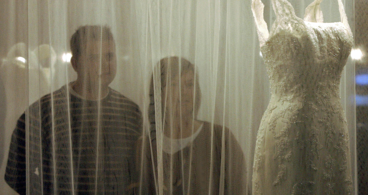 Una pareja observa un diseño de un traje de novia