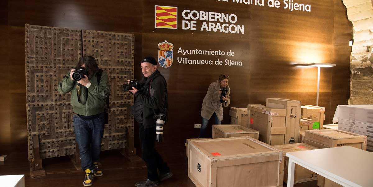 Fotógrafos sacan imágenes de las cajas con los bienes trasladados desde Lérida hasta el Monasterio de Villanueva de Sijena
