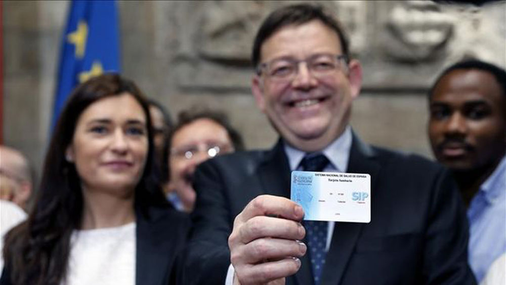 El president Ximo Puig muestra, junto a la consellera Carmen Montón, una tarjeta sanitaria.
