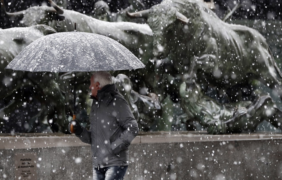 Un hombre camino bajo la nieve en Pamplona. 