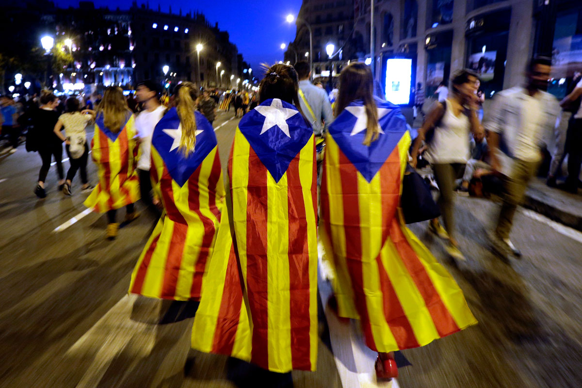 Varias jóvenes con banderas esteladas caminan por plaza de Catalunya tras una manifestación. 