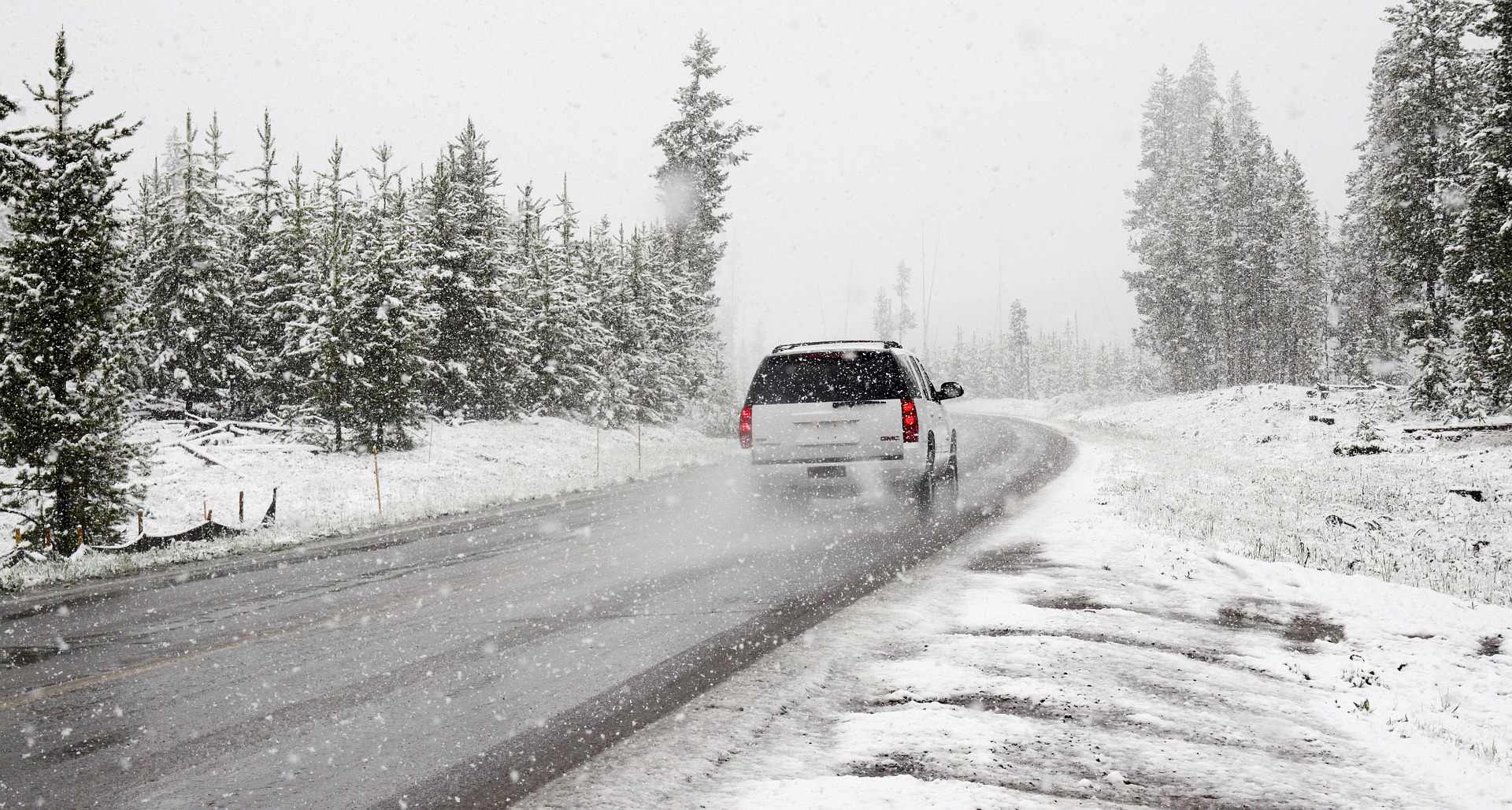 Un coche circulando por un paisaje nevado.