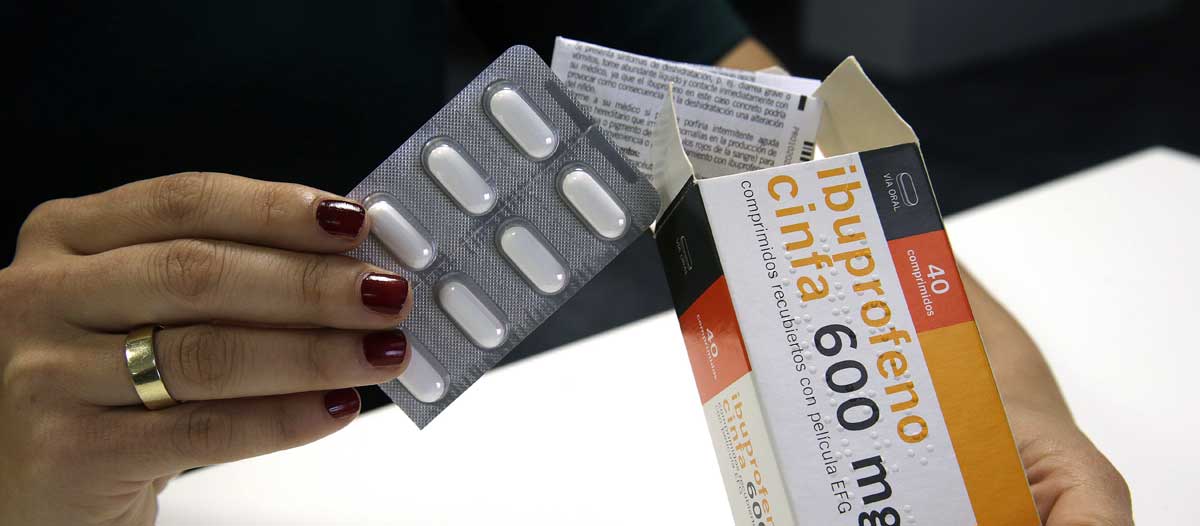 Una mujer sostiene una caja de Ibuprofeno en la mano. EFE
