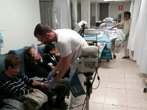 Un enfermero atiende a un paciente en el pasillo de Urgencias del Hospital La Paz