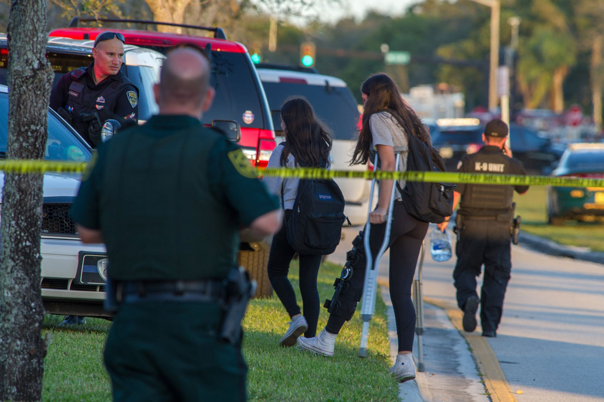 Miembros del personal de emergencias ayudan a varios estudiantes hoy, miércoles 14 de febrero de 2018, en el lugar del tiroteo registrado en la escuela secundaria Marjory Stoneman Douglas de la ciudad de Parkland, en el sureste de Florida (Estados Unidos)