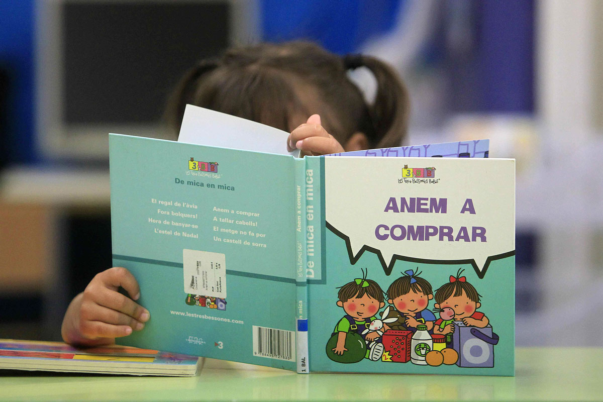 Una nena llegeix un llibre a una escola de Barcelona.