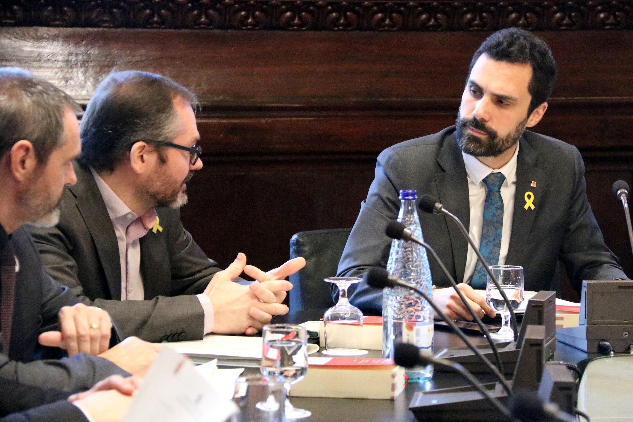 Roger Torrent mira a los diputados de JxCat Eusebi Campdepadrós y Josep Costa durante Mesa del Parlament.