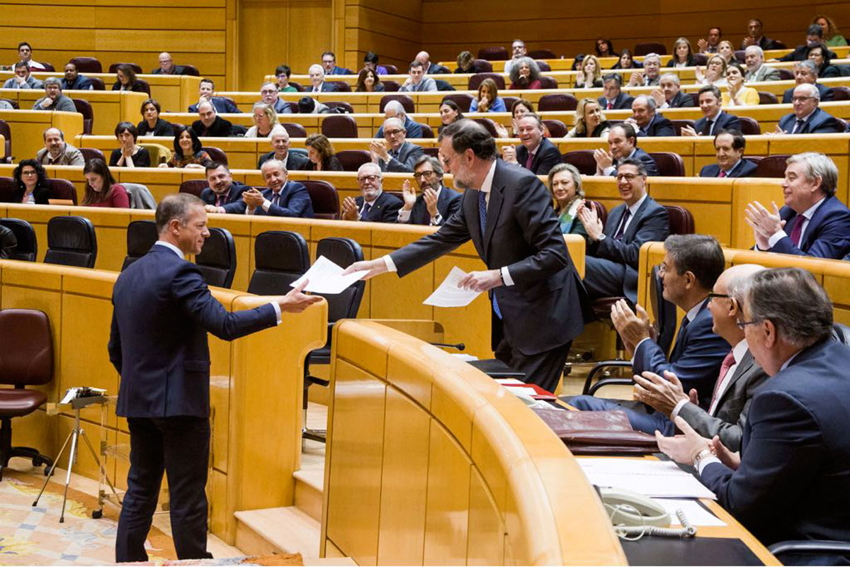 El socialista Ander Gil le entrega un documento a Mariano Rajoy en el Senado.