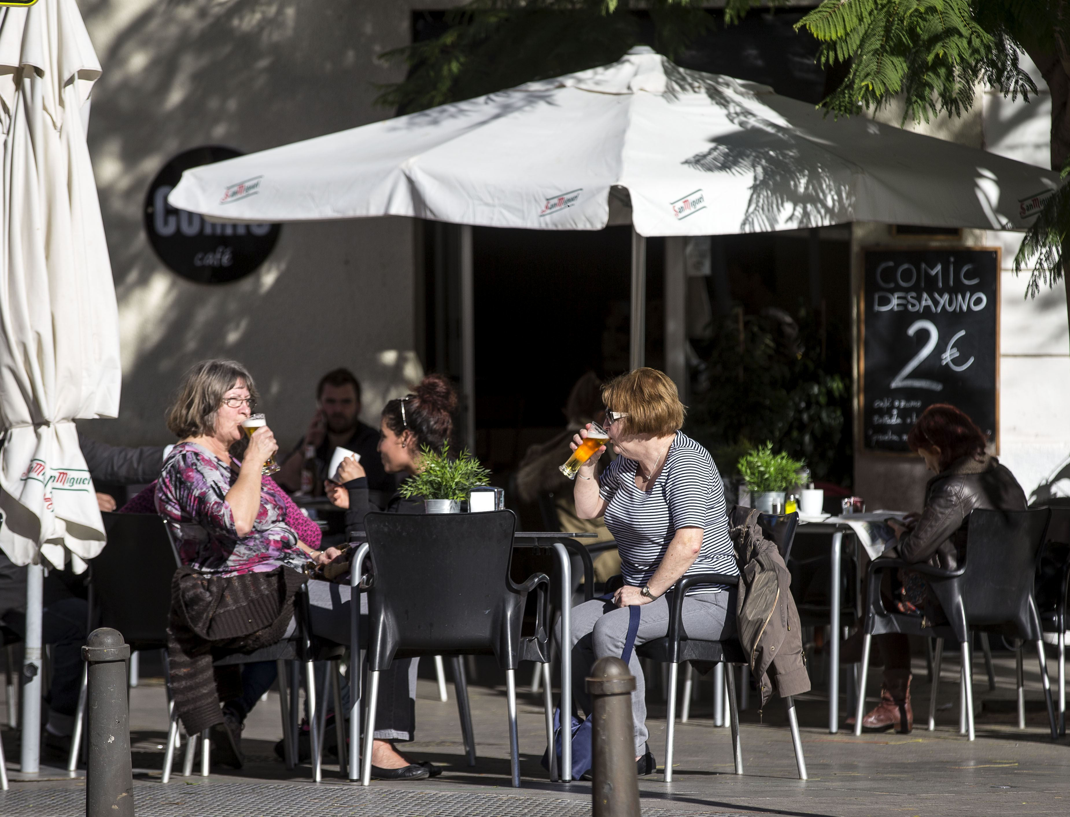 Turistas disfrutan del sol en una terraza de la plaza de la Virgen de Valencia