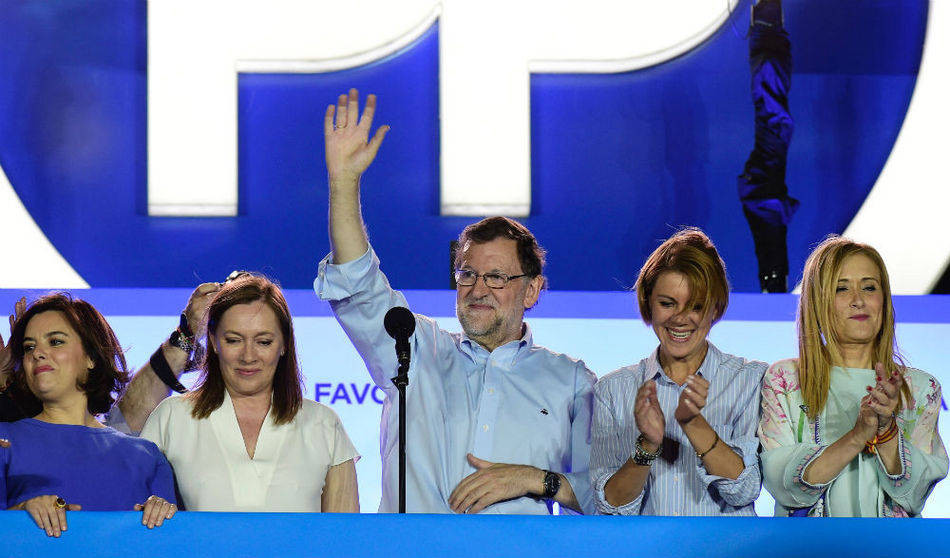 Mariano Rajoy saluda desde el balcón de la sede del PP acompañado por su esposa y por las mujeres clave de su partido: Sáenz de Santamaría, Cospedal y Cifuentes. 