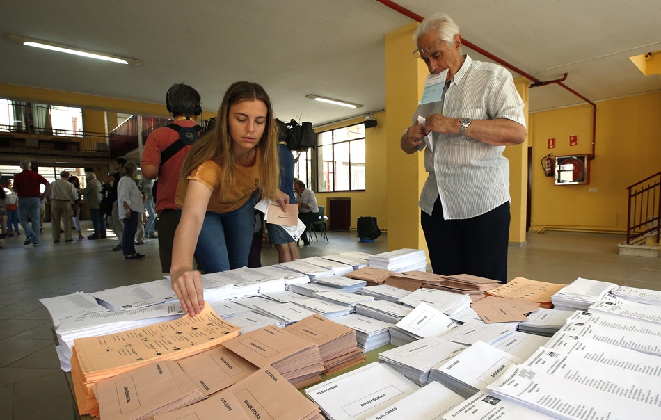 Una mujer escoge su papeleta en la jornada de elecciones generales del 26 de junio de 2016. 
