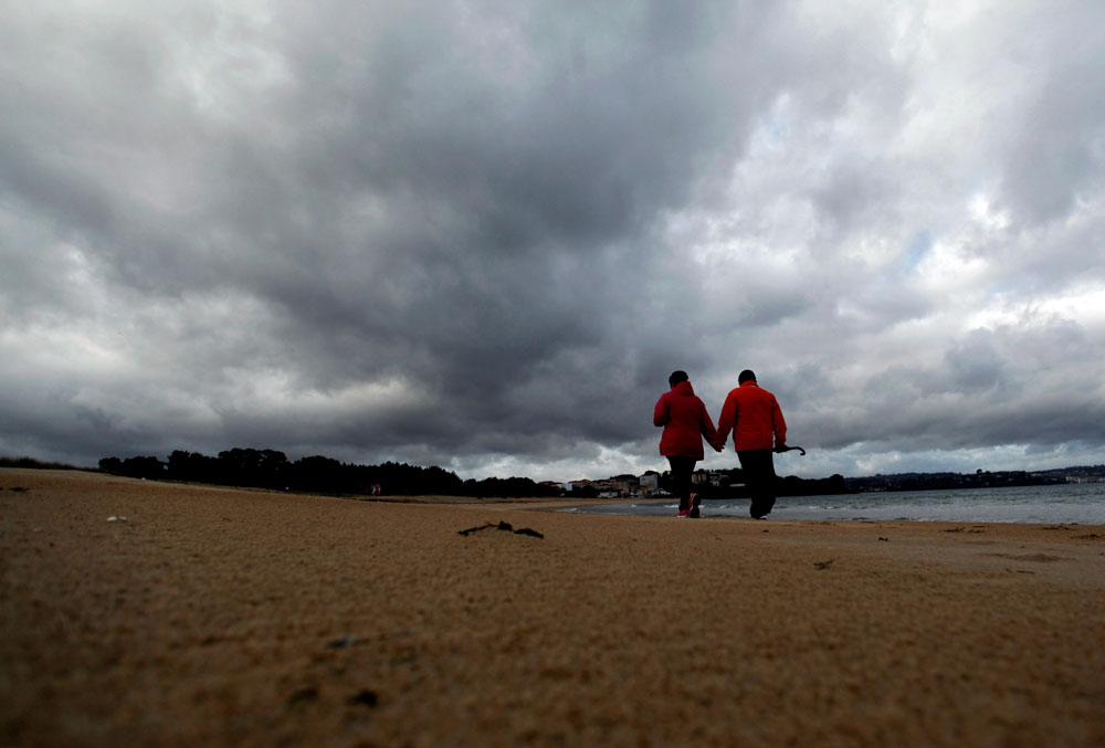 Una pareja pasea por la playa Grande de Miño