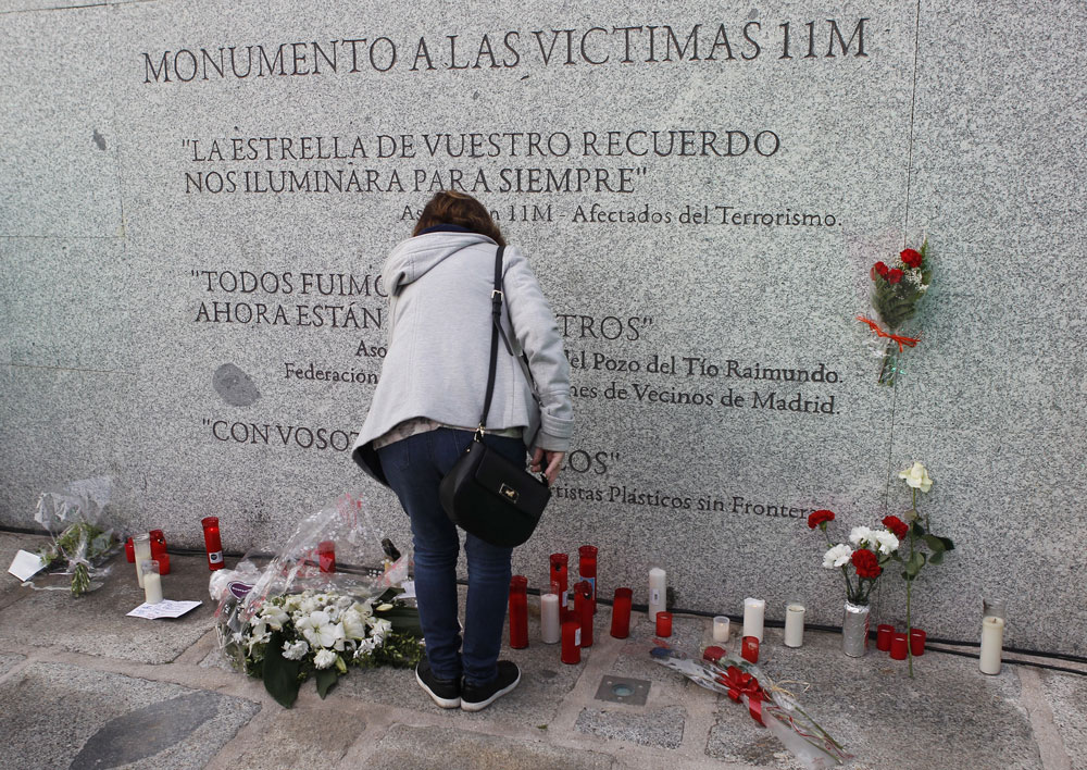 Flores y velas junto al monumento a las víctimas de los atentados del 11M, con motivo del decimocuarto aniversario de la masacre. 