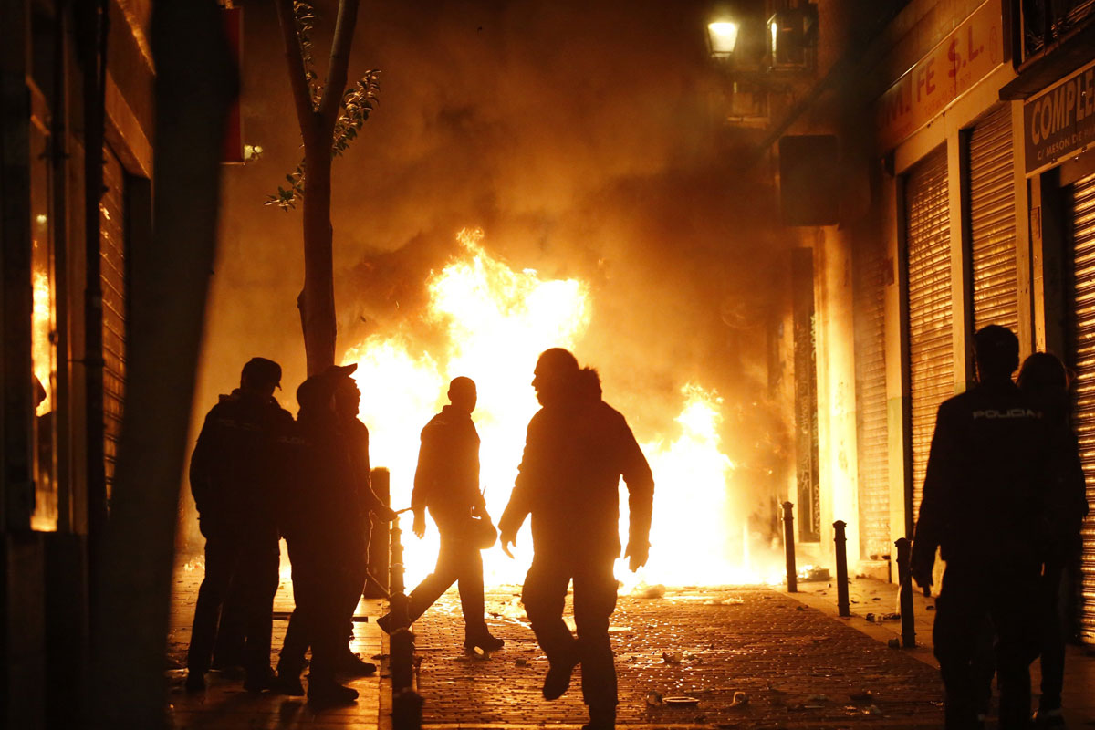 Barios contenedores quemados durante los enfrentamientos en Lavapiés