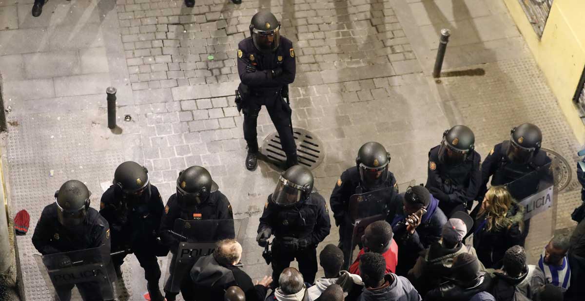 Un grupo de antidisturbios contiene a varias personas en las calles de Lavapiés. 