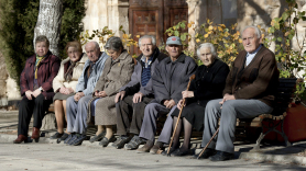 Varios ancianos toman el sol en unos bancos de Olmeda de la Cuesta, Cuenca