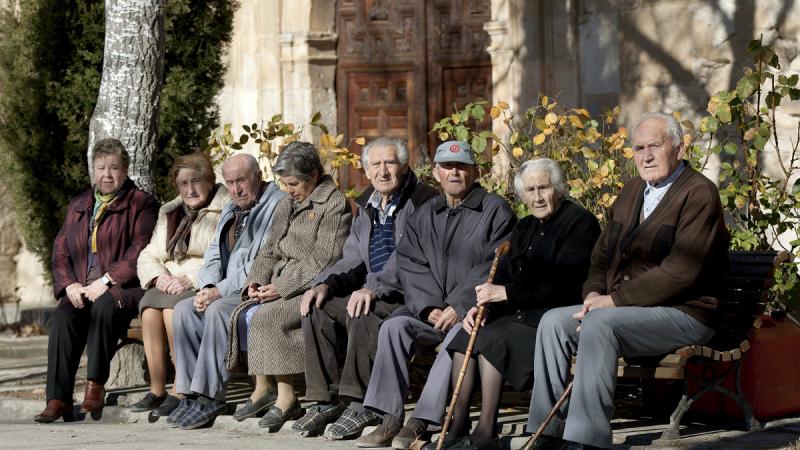 Varios ancianos sentados en un banco