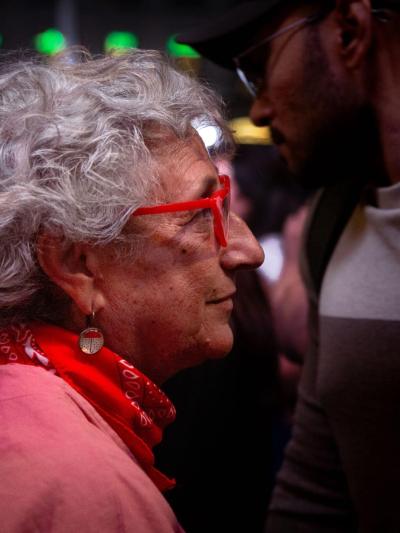 Una mujer observa a las personas que se manifiestan por el derecho a la vivienda en la Puerta del Sol. Tamara Rozas