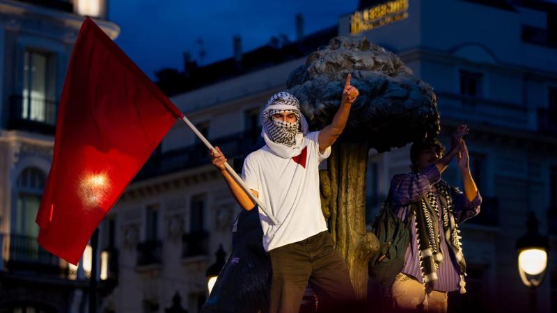 Una persona ondea una bandera roja en las protestas por la vivienda en la Puerta del Sol. Tamara Rozas