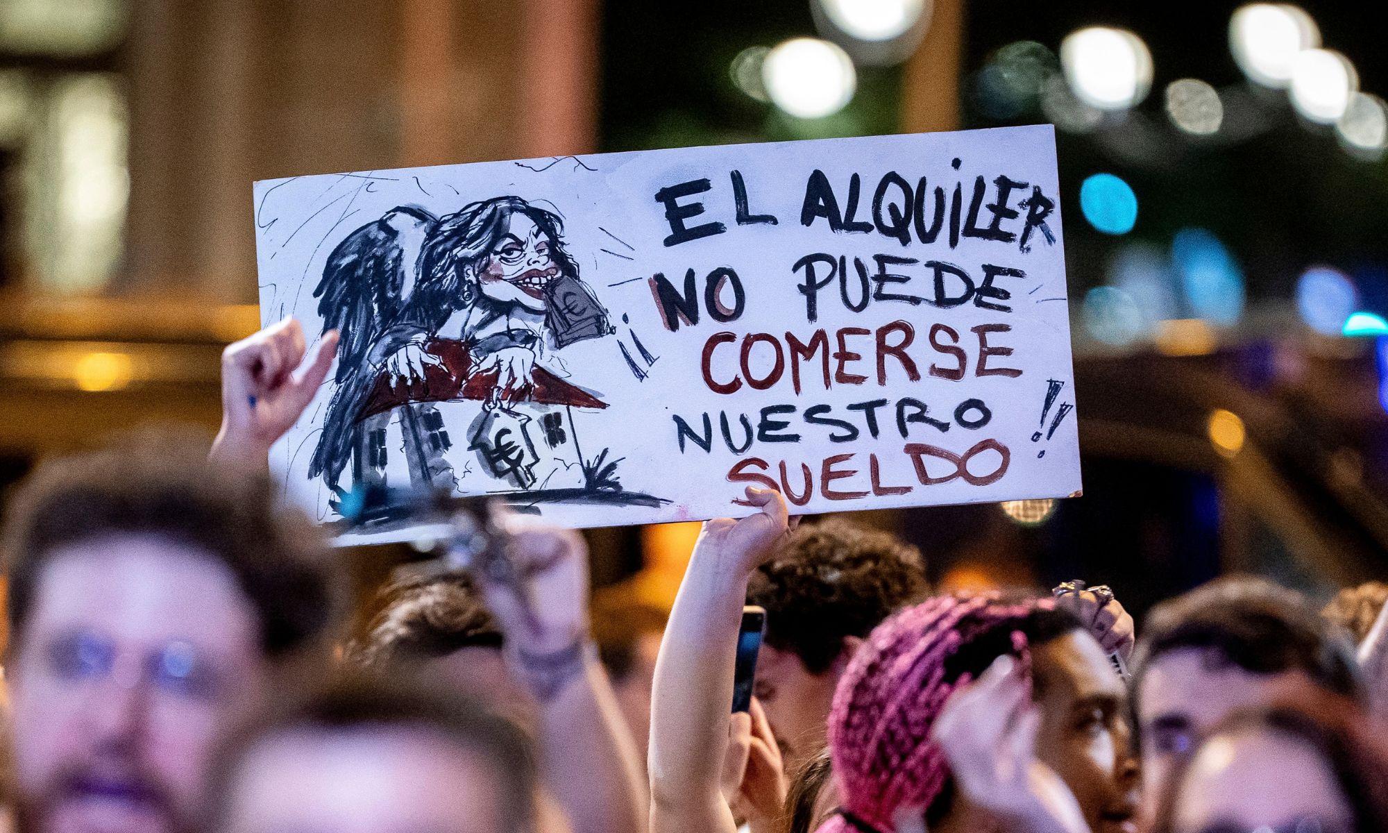 Una persona muestra una pancarta durante una cacerolada por la vivienda. EP.