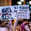 Una persona muestra una pancarta durante una cacerolada por la vivienda. EP.