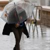 Una mujer se resguarda de la lluvia bajo un paraguas. EP.