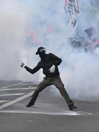 Un manifestante devuelve una granada de gas lacrimógeno durante los intensos enfrentamientos con la policía en una protesta contra las condiciones educativas. EP.