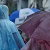 Dos personas con paraguas y chubasqueros pasen por la calle en un día de lluvias y tormentas. EP.