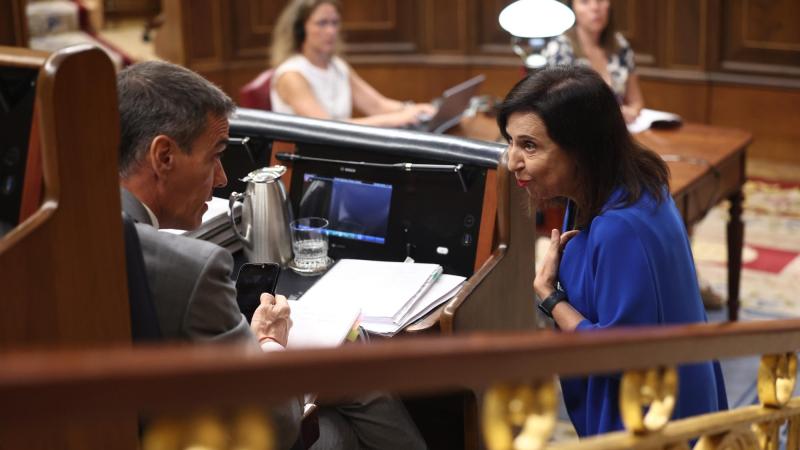 El presidente del Gobierno, Pedro Sánchez, y la ministra de Defensa, Margarita Robles, conversan durante una sesión plenaria en el Congreso de los Diputados. EP.