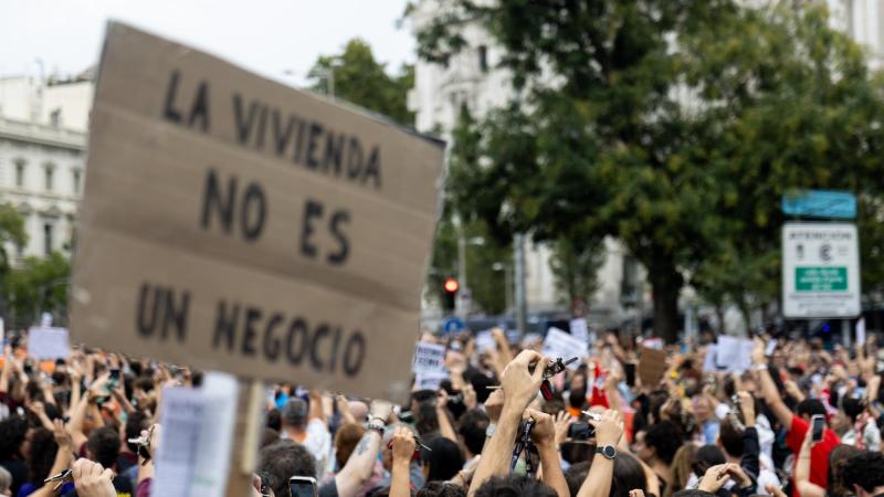 Numerosas personas sostienen una pancarta con lema 'La vivienda no es un negocio' durante la manifestación para exigir una reducción del precio de los alquileres de la vivienda. EP.