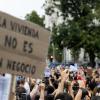 Numerosas personas sostienen una pancarta con lema 'La vivienda no es un negocio' durante la manifestación para exigir una reducción del precio de los alquileres de la vivienda. EP.