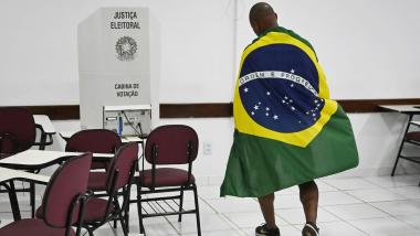 Un votante envuelto en la bandera nacional aparece en un centro de votación en Brasilia, Brasil. EP.