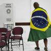 Un votante envuelto en la bandera nacional aparece en un centro de votación en Brasilia, Brasil. EP.