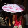 Imagen de recurso de dos mujeres compartiendo paraguas para protegerse del calor. EP/Archivo.