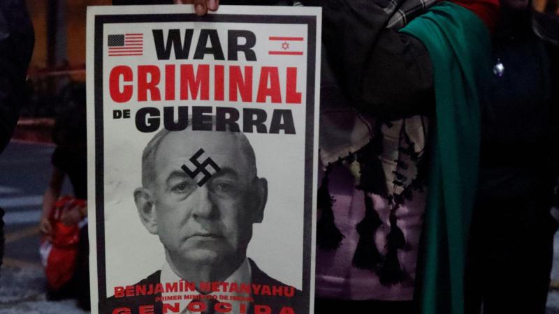 Activistas propalestinos sostienen un cartel que muestra al primer ministro israelí Benjamin Netanyahu con una esvástica superpuesta durante una manifestación frente a la Embajada de Israel en México. EP.