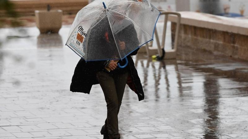 Una mujer se resguarda de la lluvia bajo un paraguas en Andalucía. EP