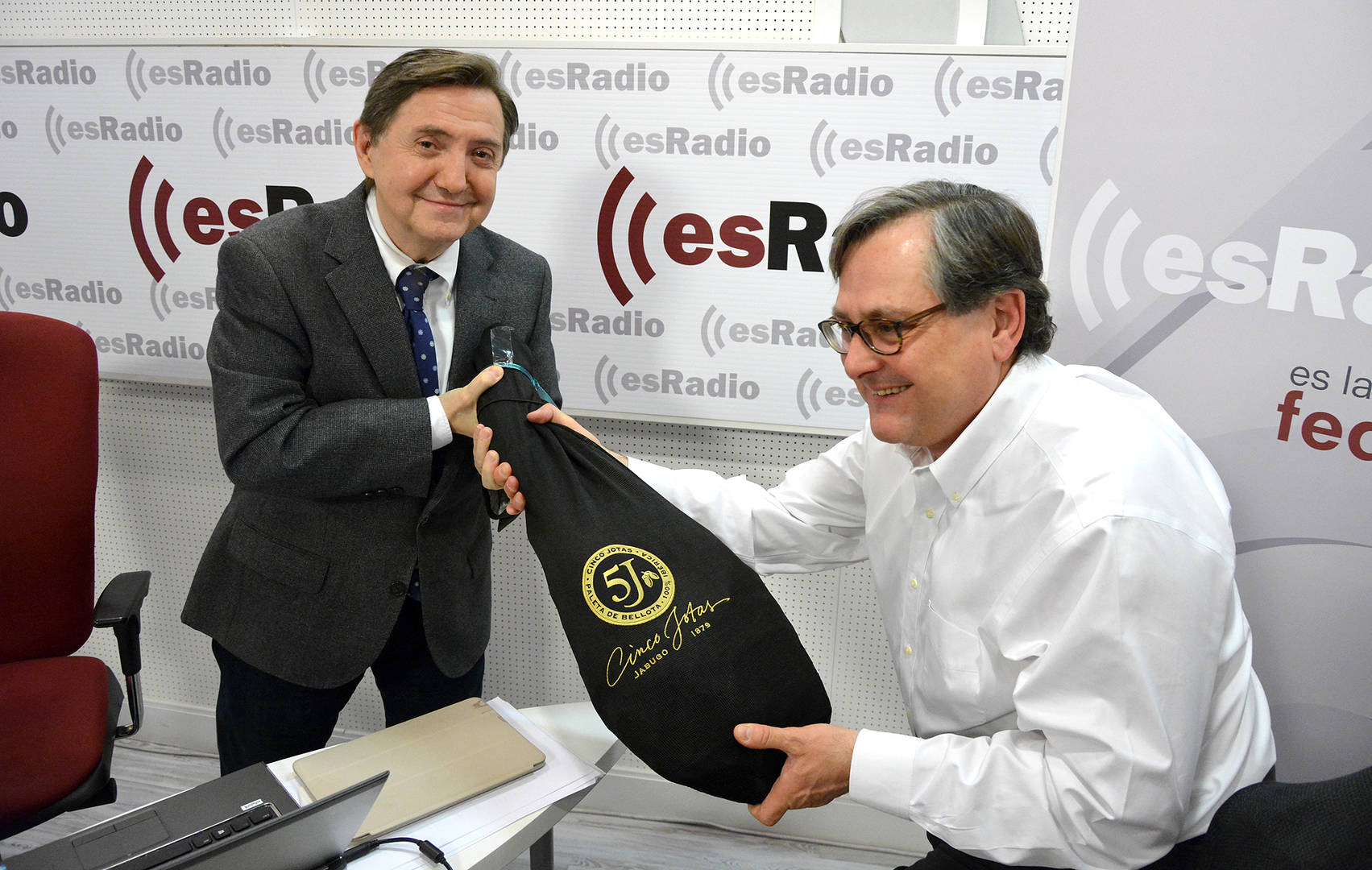 Francisco Marhuenda (derecha) entregando un jamón a Federico Jiménez Losantos (izquierda) en los estudios de esRadio